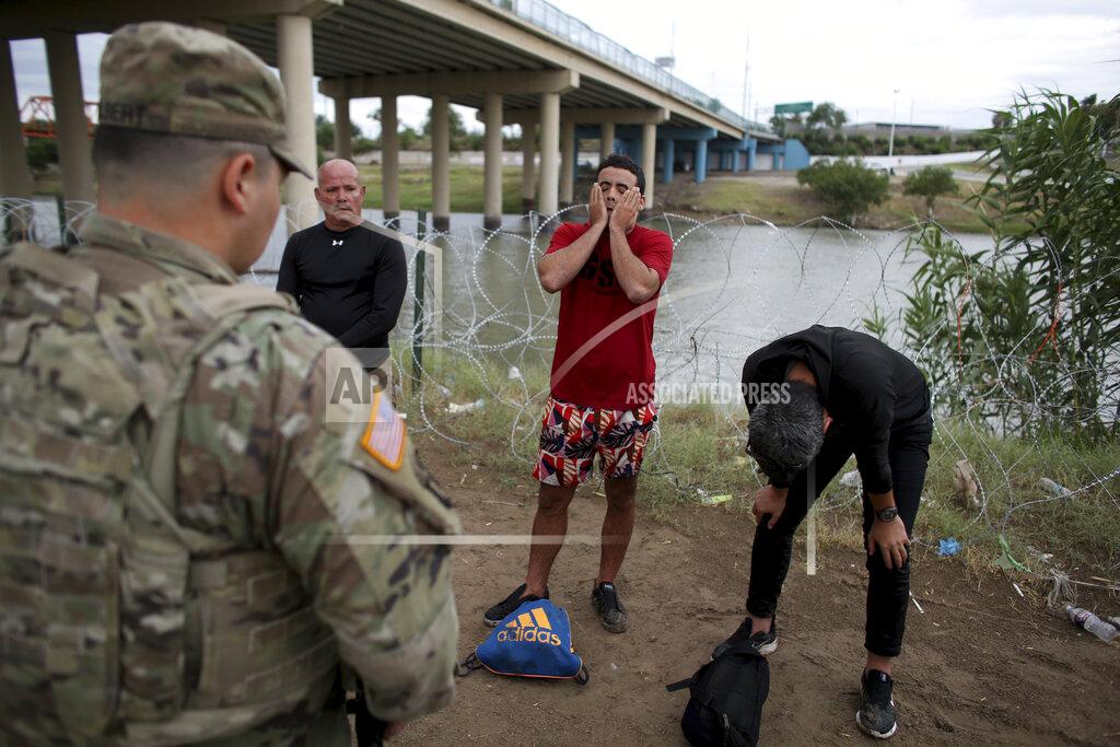 Dario Lopez-Mills Three migrants from Cuba stand in front of a National Guardsman after crossing the Rio Grande river in Eagle Pass, Texas, Sunday May 22, 2022. Little has changed in what has quickly become one of the busiest corridors for illegal border crossings since a federal judge blocked pandemic-related limits on seeking asylum from ending Monday. (AP Photo/Dario Lopez-Mills)