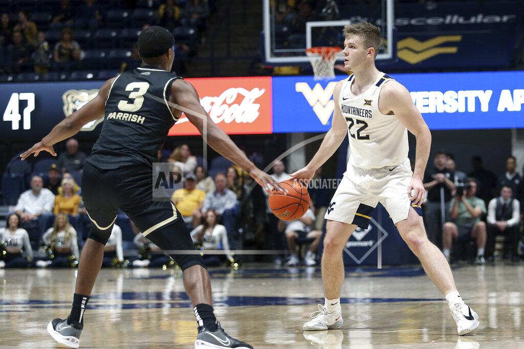 Kathleen Batten West Virginia guard Sean McNeil (22) looks for an opening as Oakland forward Micah Parrish (3) defends during the second half of an NCAA college basketball game in Morgantown, W.Va., Tuesday, Nov. 9, 2021. (AP Photo/Kathleen Batten)