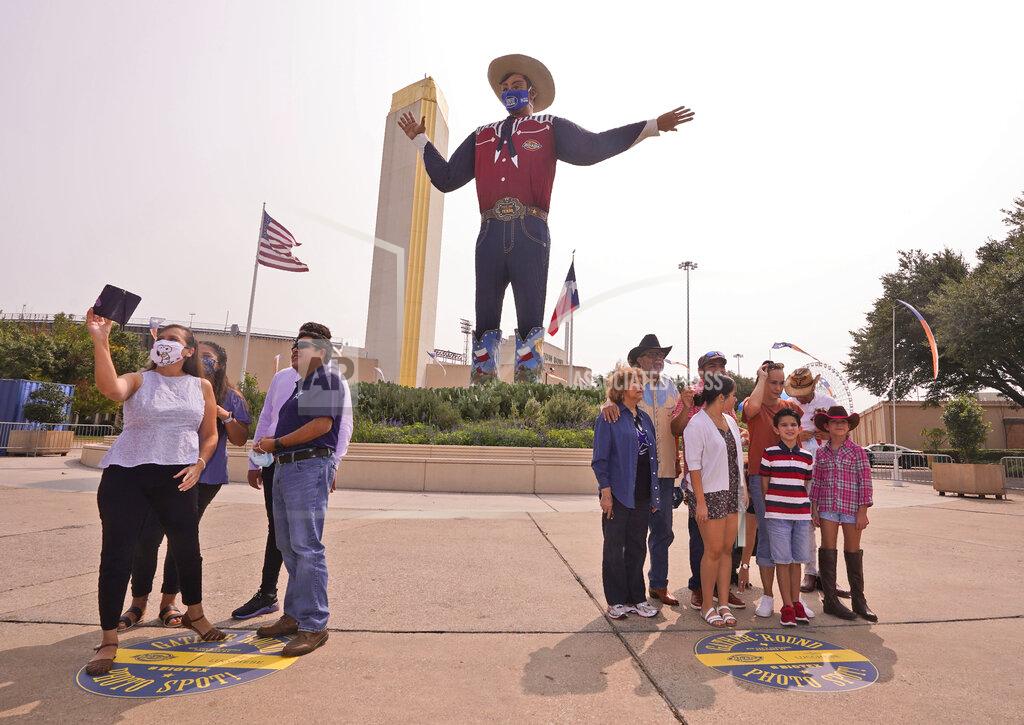 Lm Otero With the famous giant Big Tex as the background, families pose for photos during a drive-thru visit to Fair Park in Dallas, Saturday, Sept. 19, 2020. Although the State Fair of Texas was canceled this year due to COVID-19, fair organizers are holding drive-thru visits starting this weekend. (AP Photo/LM Otero)