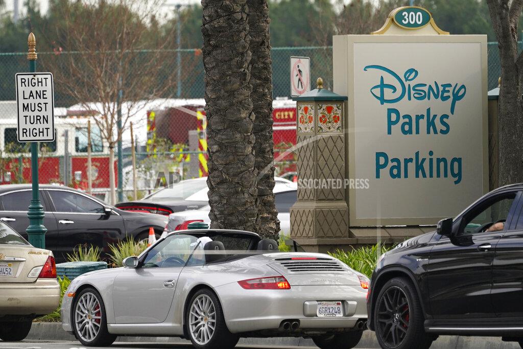 FILE - In this Jan. 13, 2021, file photo, vehicles queue up outside the Disneyland Resort parking lot for a COVID-19 vaccine in Anaheim, Calif. California has closed some vaccination centers and delayed appointments following winter storms elsewhere in the country that hampered the shipment of doses. Orange County shut its large-scale vaccination site at Disneyland through Monday, Feb. 22, 2021, after a shipment of Moderna COVID-19 vaccine doses didn't arrive this week. (AP Photo/Damian Dovarganes, File)