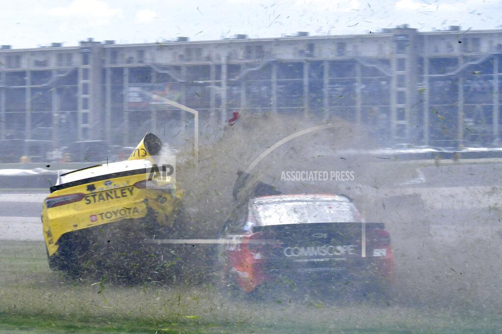 Randy Crist Christopher Bell (20) and Daniel Suarez (99) slide out during a massive crash caused by a piece of curbing during a NASCAR Series auto race at Indianapolis Motor Speedway, Sunday, Aug. 15, 2021, in Indianapolis. (Randy Crist/The Indianapolis Star via AP)