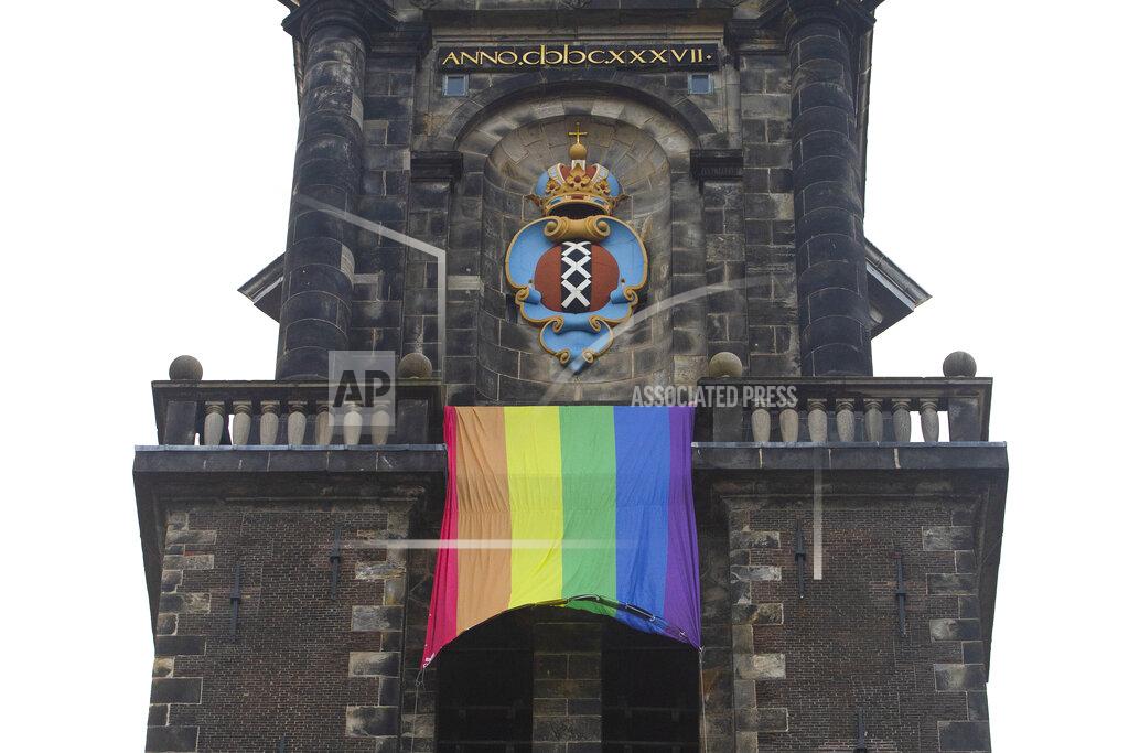 Peter Dejong A large rainbow flag flies from the bell tower of Wester Church to mark the 20th anniversary of the first legalized same-sex marriage in Amsterdam, Netherlands, Thursday, April 1, 2021. Twenty years ago, the mayor of Amsterdam married four couples in City Hall as the Netherlands became the first country in the world with legalized same-sex marriage. It's now legal in 28 countries. The three crosses of the coat of arms of the city of Amsterdam are seen above the flag. (AP Photo/Peter Dejong)