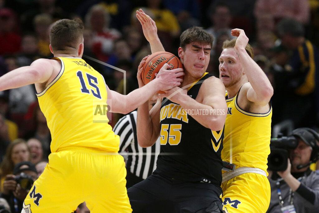 Kiichiro Sato Iowa's Luka Garza (55) battles for the possession of the ball against Michigan's Jon Teske (15) during the first half of an NCAA college basketball game in the quarterfinals of the Big Ten Conference tournament, Friday, March 15, 2019, in Chicago. (AP Photo/Kiichiro Sato)