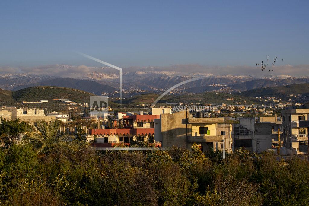 Hassan Ammar Pigeons fly as the sun sets over the town of Bhannine in the northern city of Tripoli, Lebanon, Tuesday, April 13, 2021. For many Syrian refugee families in Lebanon, Ramadan comes as a hard life of displacement has gotten even harder after a pandemic year that deepened economic woes in their host country. (AP Photo/Hassan Ammar)