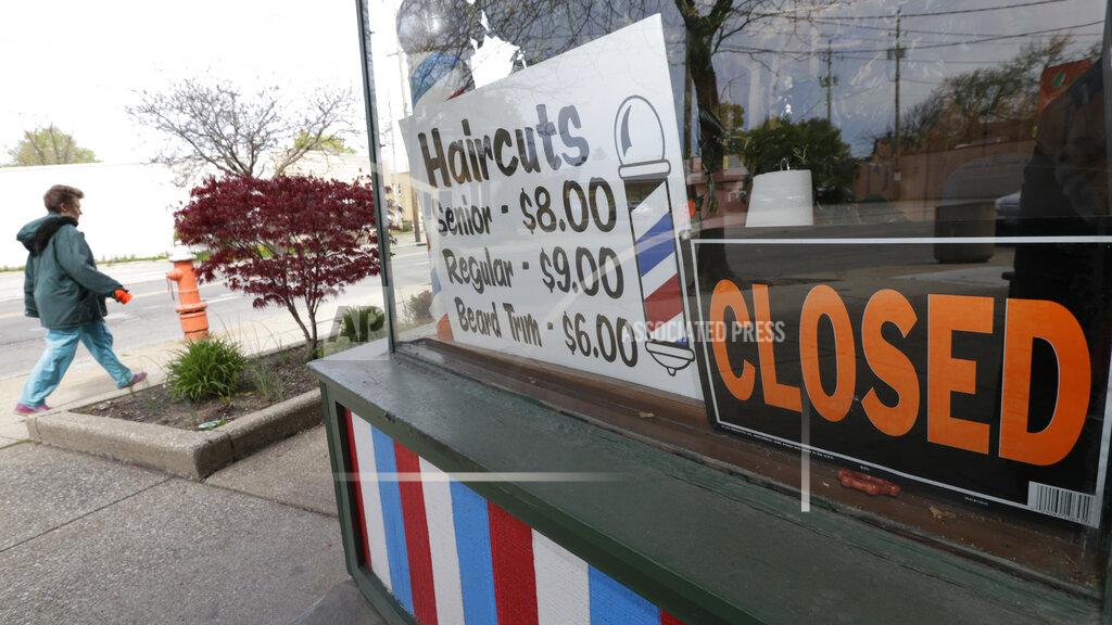 Tony Dejak FILE - In this May 6, 2020 file photo, a woman walks past a closed barber shop in Cleveland. Small businesses are in limbo again as the coronavirus outbreak rages and the government’s $659 billion relief program draws to a close. Companies still struggling with sharply reduced revenue are wondering if Congress will give them a second chance at the Paycheck Protection Program, which ends Friday, Aug. 7, after giving out 5.1 million loans worth $523 billion. (AP Photo/Tony Dejak, File)
