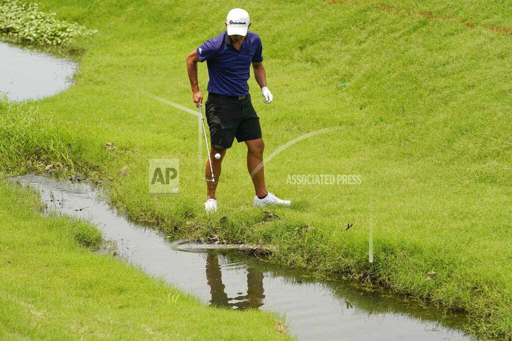 Eric Gay Collin Morikawa fishes his ball out of the creek on the seventh hole during a practice round for the PGA Championship golf tournament, Tuesday, May 17, 2022, in Tulsa, Okla. (AP Photo/Eric Gay)