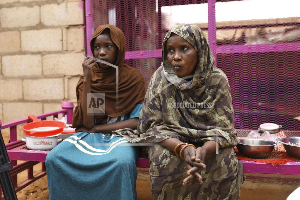 Marwan Ali Saadia Ahmed, mother of the Sudanese migrant Mutawakel Ali, sits with her daughter at her home, in Khartoum, Sudan, Friday April 30, 2021. Ali narrowly missed drowning in Libya because he was late for the boat’s departure. The rubber boat when on to sink at sea on approximately April 21, and its more than 100 passengers drowned. (AP Photo/Marwan Ali)