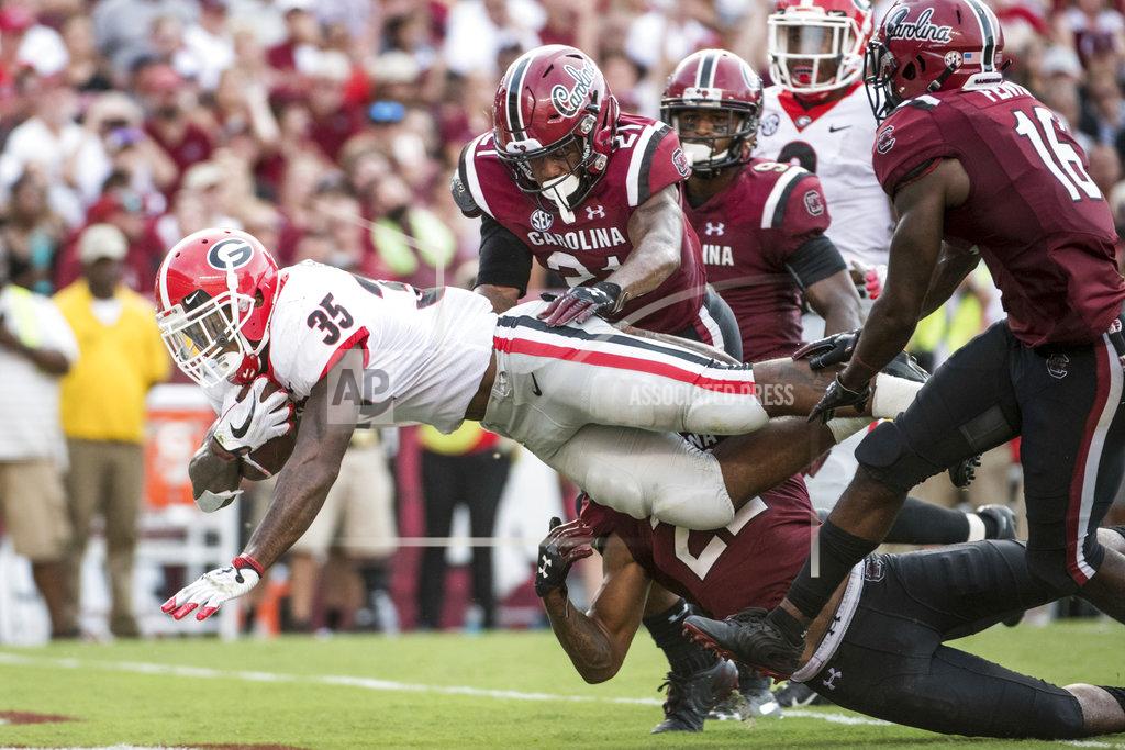 Sean Rayford Georgia running back Brian Herrien (35) scores a touchdown against South Carolina defensive back Jamyest Williams (21) and Rashad Fenton (16) during the second half of an NCAA college football game Saturday, Sept. 8, 2018, in Columbia, S.C. Georgia defeated South Carolina 41-17. (AP Photo/Sean Rayford)