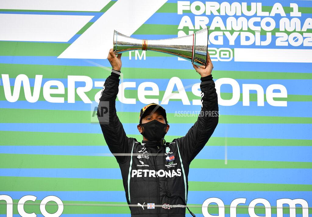 Joe Klamar Mercedes driver Lewis Hamilton of Britain celebrates on the podium after winning the Hungarian Formula One Grand Prix at the Hungaroring racetrack in Mogyorod, Hungary, Sunday, July 19, 2020. (Joe Klamar/Pool via AP)