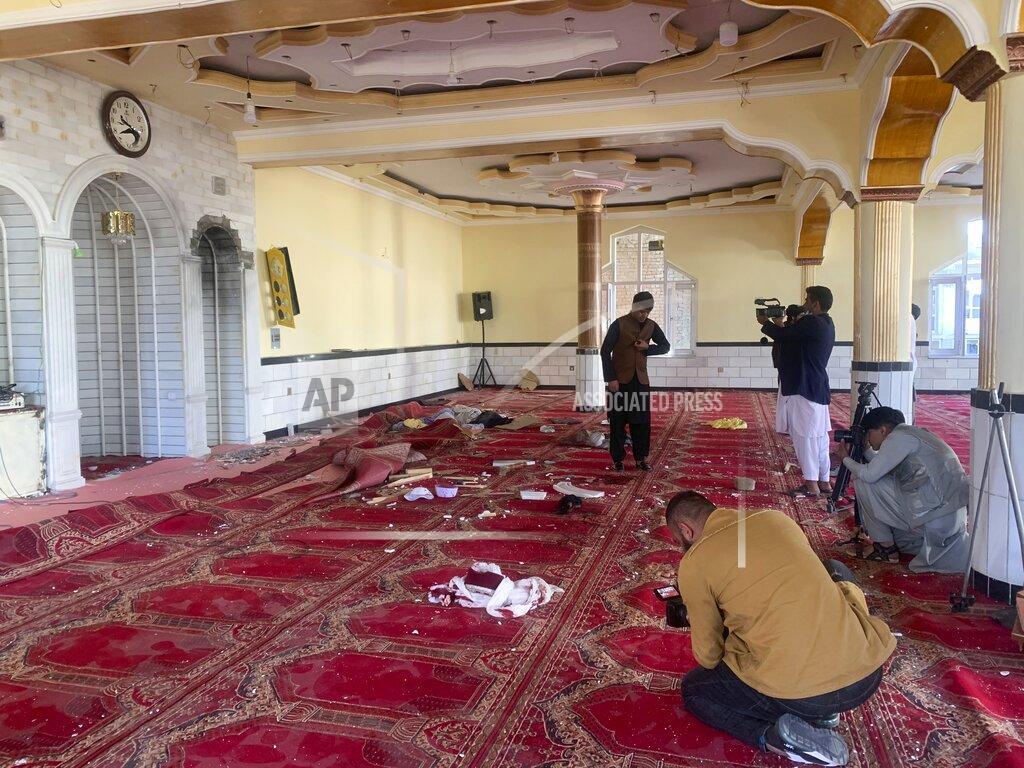 Rahmat Gul Afghan journalist take photos and film inside a mosque after a bomb explosion in Shakar Dara district of Kabul, Afghanistan, Friday, May 14, 2021. A bomb ripped through a mosque in northern Kabul during Friday prayers killing 12 worshippers, Afghan police said. (AP Photo/Rahmat Gul)