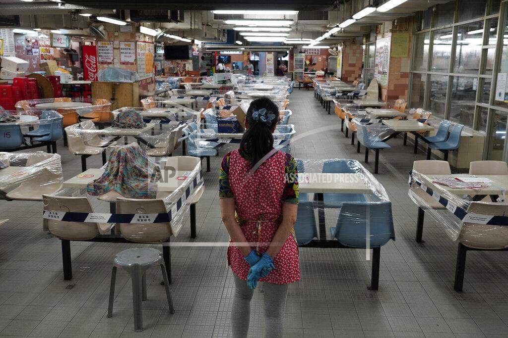 Vincent Yu A restaurant employee looks at empty sits at a Chinese food court in Hong Kong, Wednesday, July 29, 2020. Hong Kong has banned dining-in at restaurants completely on Wednesday and make it mandatory to wear masks in all public places, as the city battles its worst coronavirus outbreak to date. (AP Photo/Vincent Yu)