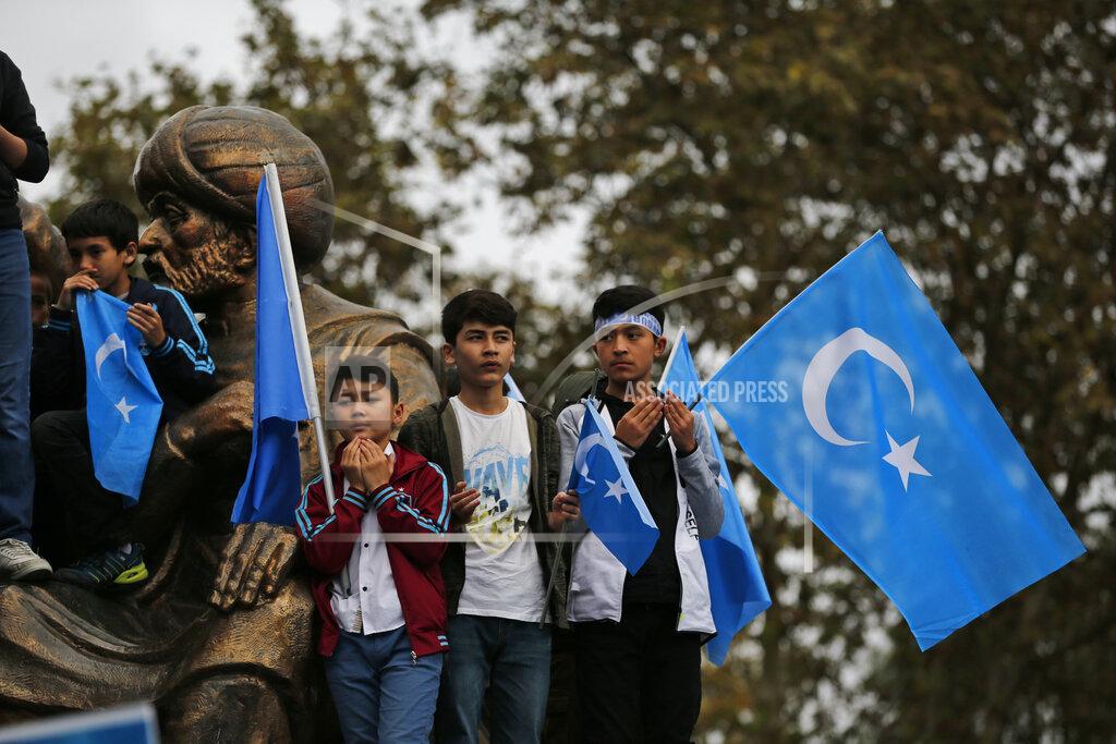 Lefteris Pitarakis FILE - In this Tuesday, Nov. 6, 2018, file photo, members of the Uighur community living in Turkey, some carrying flags of what ethnic Uighurs call 'East Turkestan', pray during a protest in Istanbul, against what they allege is oppression by the Chinese government to Muslim Uighurs in far-western Xinjiang province. Because of shared cultural ties, Turkey has long been a safe haven for the Uighurs, a Turkic group native to China's far west Xinjiang region. Many in the community are anxious they may be deported back to China amid allegations of an exchange of Uighurs for coronavirus vaccines. (AP Photo/Lefteris Pitarakis, File)