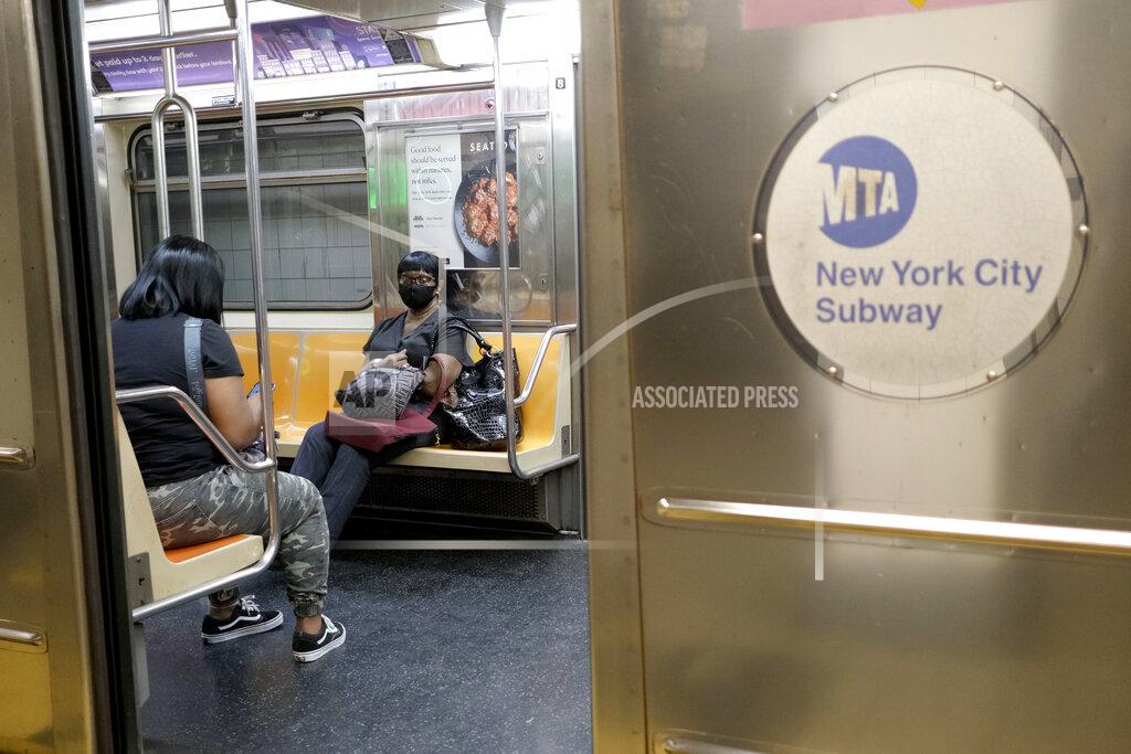 Commuters ride uncrowded subways in New York, Monday, June 8, 2020. After three months of a coronavirus crisis followed by protests and unrest, New York City is trying to turn a page when a limited range of industries reopen Monday. (AP Photo/Seth Wenig)