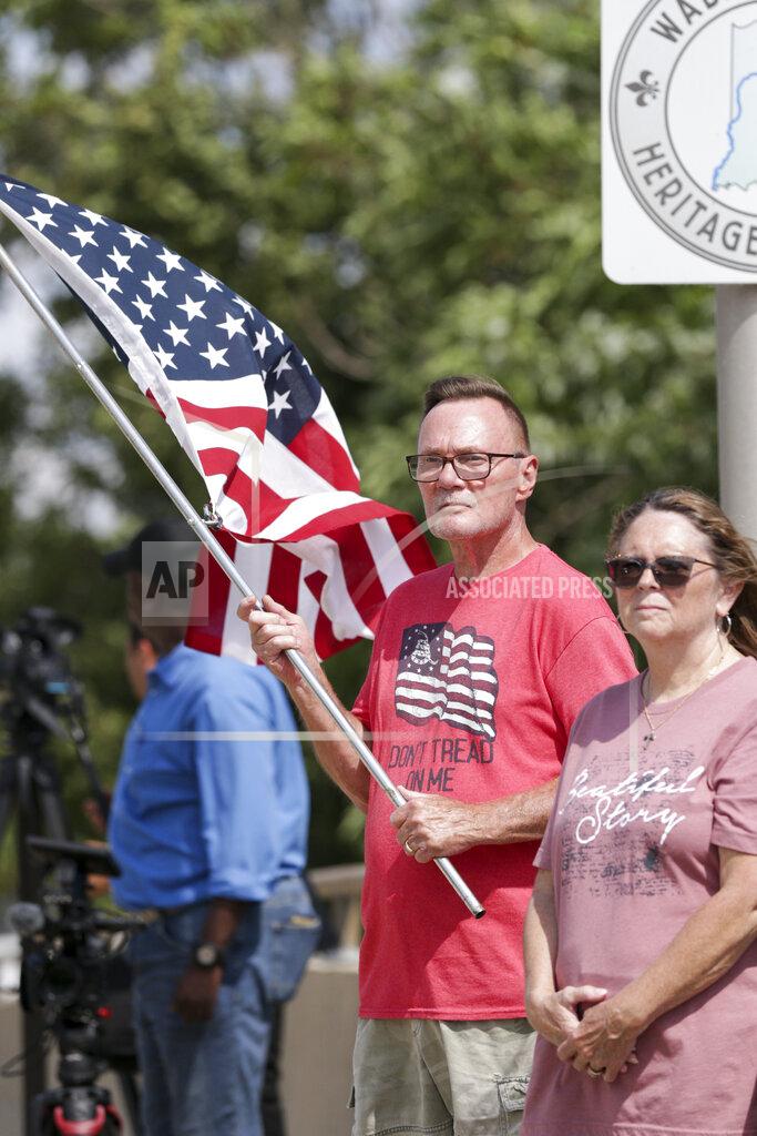Nikos Frazier Jeff DuBois holds an American flag as the funeral procession for Marine Cpl. Humberto "Bert" Sanchez passes by, Tuesday, Sept. 14, 2021, in Logansport, Ind. Sanchez was one of 13 U.S. service members to die in an explosion during evacuation efforts in Afghanistan. (Nikos Frazier/Journal & Courier via AP)