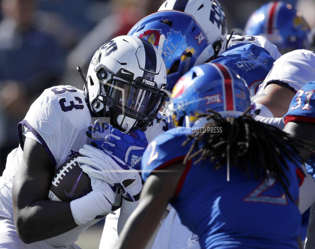 Orlin Wagner TCU running back Sewo Olonilua (33) is stopped by Kansas defensive tackle J.J. Holmes and Kansas cornerback Corione Harris (2) during the first half of an NCAA college football game in Lawrence, Kan., Saturday, Oct. 27, 2018. (AP Photo/Orlin Wagner)