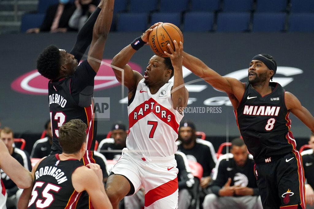 Chris O'meara Toronto Raptors guard Kyle Lowry (7) goes to the basket between Miami Heat forward Bam Adebayo (13) and forward Maurice Harkless during the first half of an NBA preseason basketball game Friday, Dec. 18, 2020, in Tampa, Fla. The Raptors are playing their home games in Tampa as a result of Canada's strict travel regulations stemming from the coronavirus pandemic. (AP Photo/Chris O'Meara)