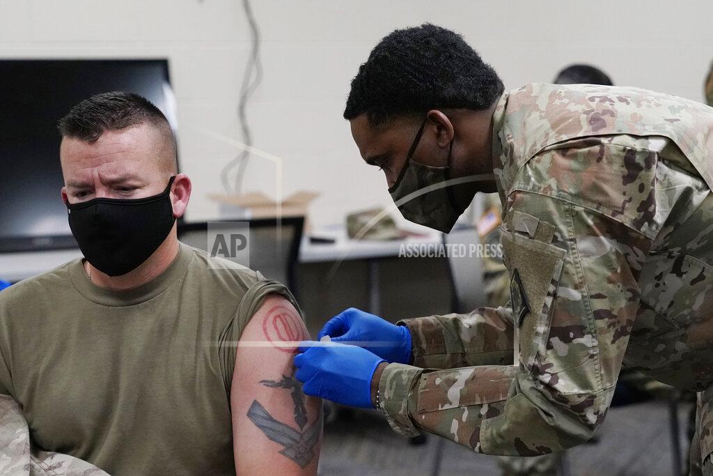 Rogelio V. Solis Maj. Michael Childress receives a bandage from Sgt. Christian Minor after being inoculated with the Moderna COVID-19 vaccine at the Mississippi National Guard's 172d Airlift Wing facility in Flowood, Miss., Wednesday, Dec. 23, 2020. One hundred doses of the vaccine were administered to both Mississippi Air and Army National Guard service members who serve as first responders and currently assist with the administering of the COVID-19 test at Mississippi Department of Health drive through community testing sites across the state. (AP Photo/Rogelio V. Solis)