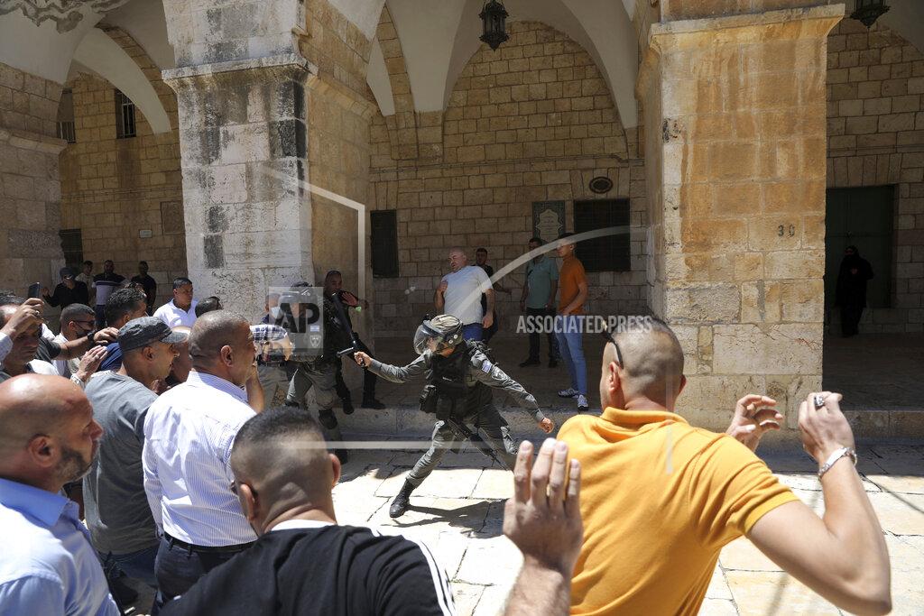 Mahmoud Illean Israeli border police swing their batons at Muslim worshippers to prevent them from gathering for Friday prayers at the Dome of the Rock Mosque in the Al-Aqsa Mosque compound in the Old City of Jerusalem, Friday, May 14, 2021. (AP Photo/Mahmoud Illean)