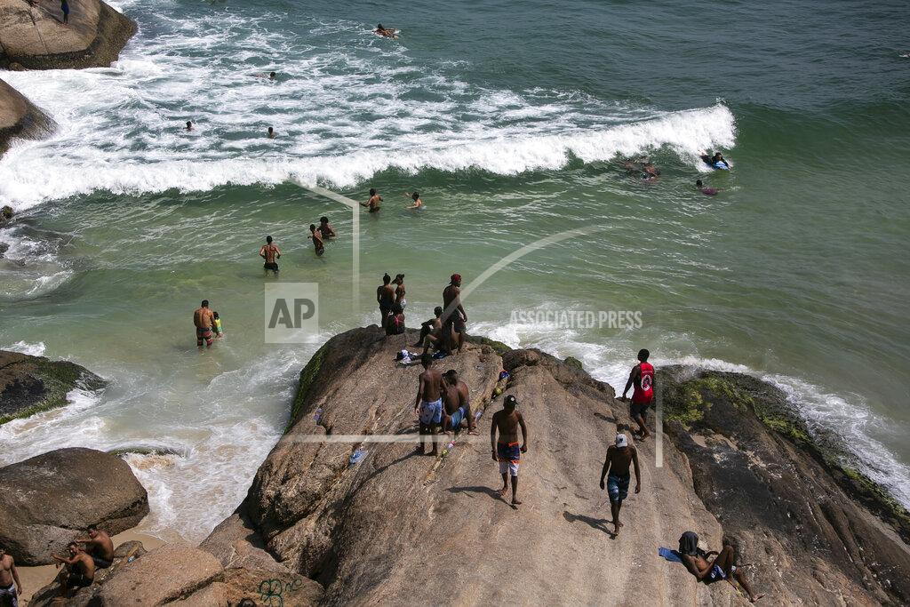 People enjoy the Ipanema beach amid the new coronavirus pandemic in Rio de Janeiro, Brazil, Sunday, Sept.6, 2020. Brazilians are packing the beaches and bars this weekend, taking advantage of a long holiday to indulge in normal life even as the COVID-19 pandemic rages on. (AP Photo/Bruna Prado)
