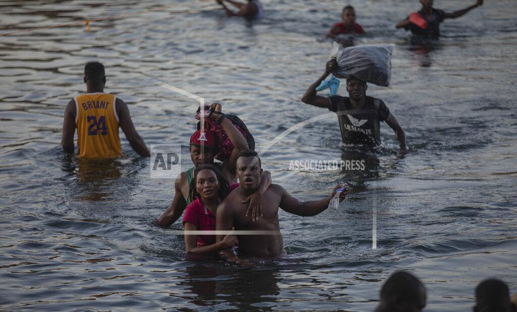 Felix Marquez Migrants wade across the Rio Grande from Del Rio, Texas, to Ciudad Acuña, Mexico, Sunday, Sept. 19, 2021. (AP Photo/Felix Marquez)