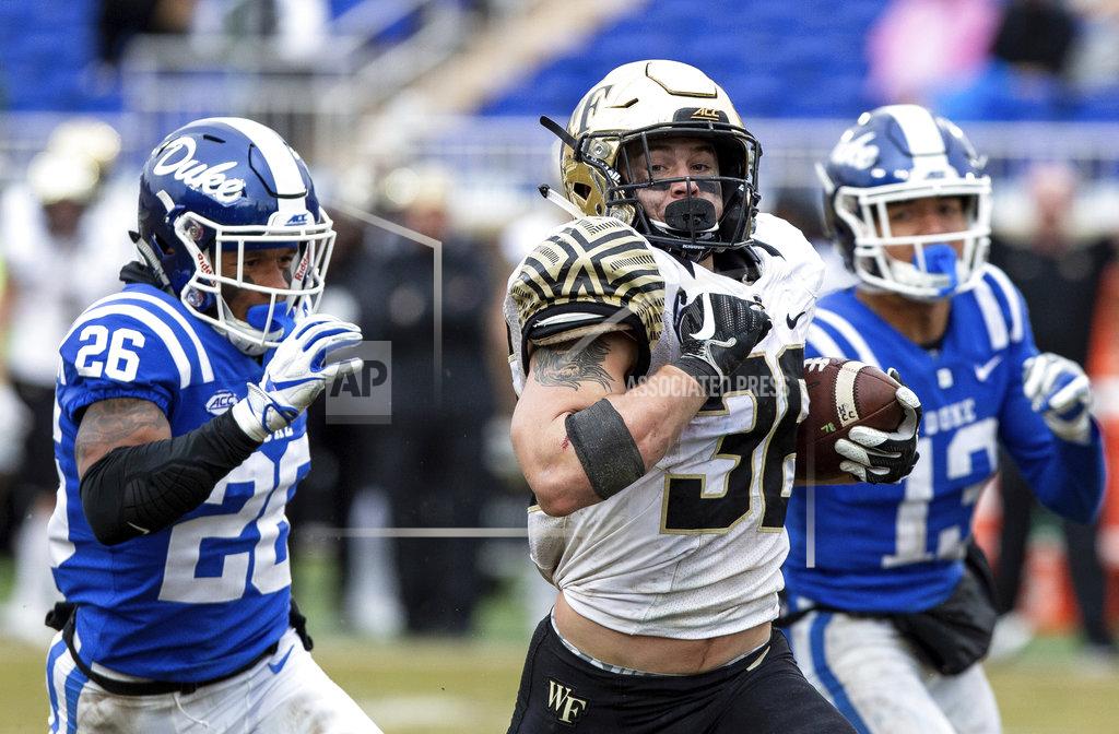 Ben Mckeown Wake Forest's Cade Carney (36) rushes past Duke's Troy Duncan (26) and Jordan Hayes (13) during the second half of an NCAA college football game in Durham, N.C., Saturday, Nov. 24, 2018. (AP Photo/Ben McKeown)