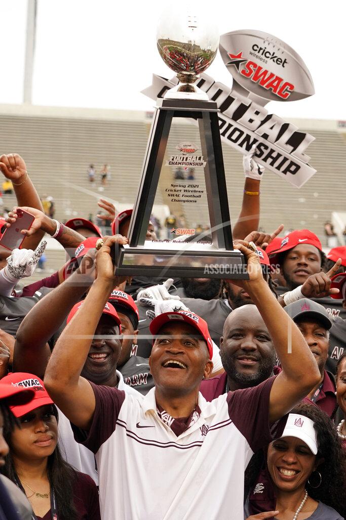 Rogelio V. Solis Alabama A&M head coach Connell Maynor hoists the the Southwestern Athletic Conference championship trophy following their NCAA college football game against Arkansas-Pine Bluff, Saturday, May 1, 2021, in Jackson, Miss. Alabama A&M won 40-33. (AP Photo/Rogelio V. Solis)