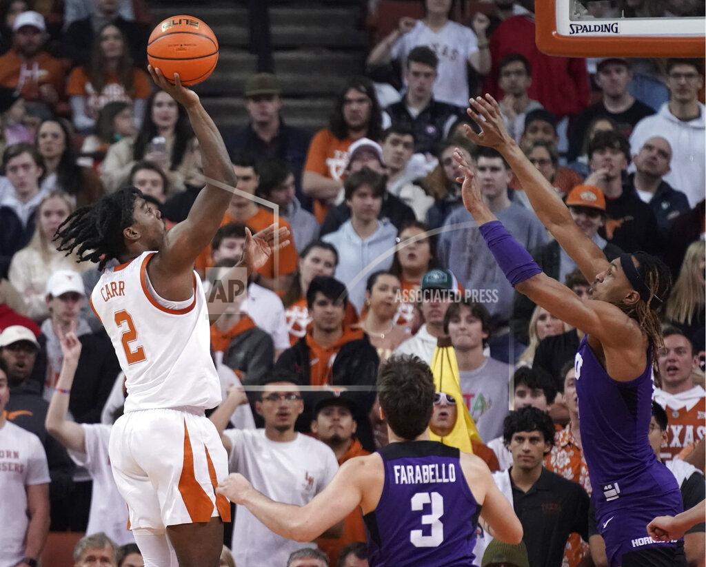 Chuck Burton Texas guard Marcus Carr (2) shoots against TCU guard Francisco Farabello (3) and forward Xavier Cork, right, during the first half of an NCAA college basketball game in Austin, Texas, Wednesday, Feb. 23, 2022. (AP Photo/Chuck Burton)