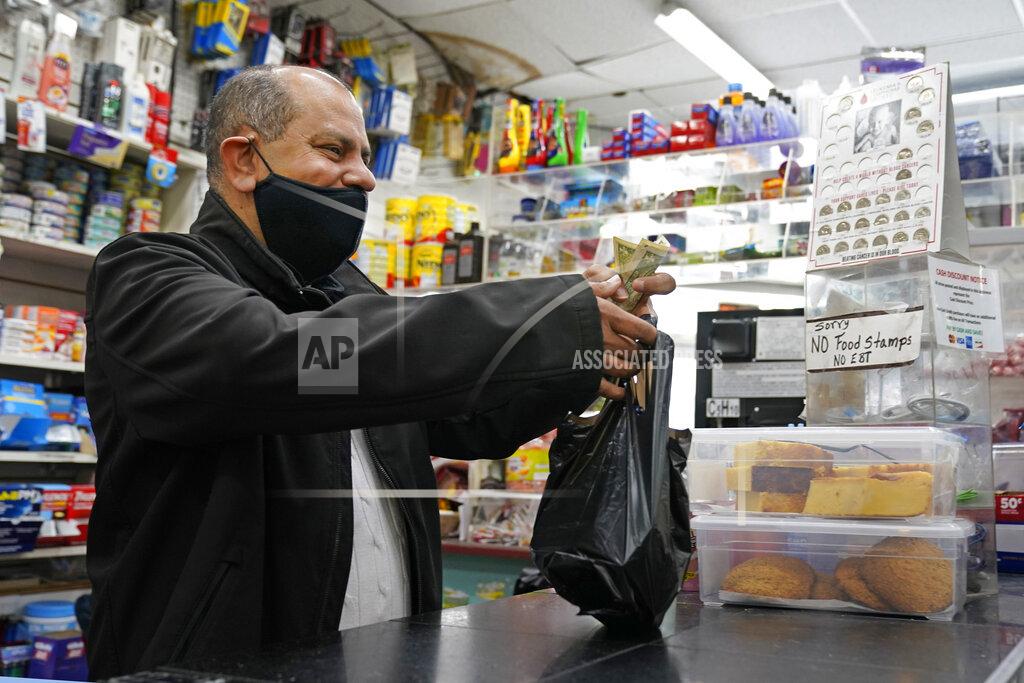Kathy Willens Bodega owner Francisco Marte assists a customer, Wednesday, Feb. 10, 2021, at his store in the Bronx borough of New York. Marte heads up the Bodega and Small Business Group, which represents bodegas in New York. (AP Photo/Kathy Willens)