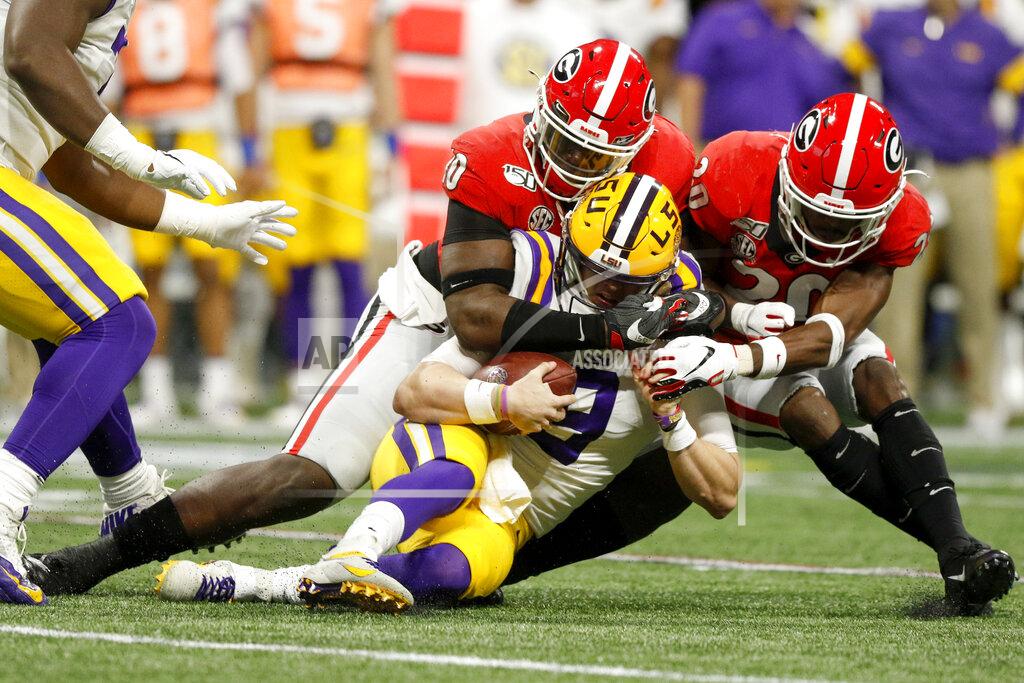 C.b. Schmelter Georgia defensive lineman Malik Herring (10) and defensive back J.R. Reed (20) hit LSU quarterback Joe Burrow (9) during an NCAA college football game for the Southeastern Conference championship Saturday, Dec. 7, 2019, in Atlanta, Ga. (C.B. Schmelter/Chattanooga Times Free Press via AP)