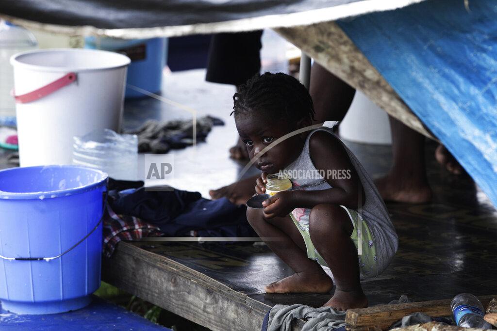 Arnulfo Franco A migrant child peeks out from under a tent at a migrant camp amid the new coronavirus pandemic, in Lajas Blancas, Darien province, Panama, Saturday, Aug. 29, 2020. Panama's government says it has built, along with the U.N. High Commissioner for Refugees, a new camp with better shelter on the outskirts of Meteti where it hopes to soon move 400 migrants, especially families with young children. (AP Photo/Arnulfo Franco)