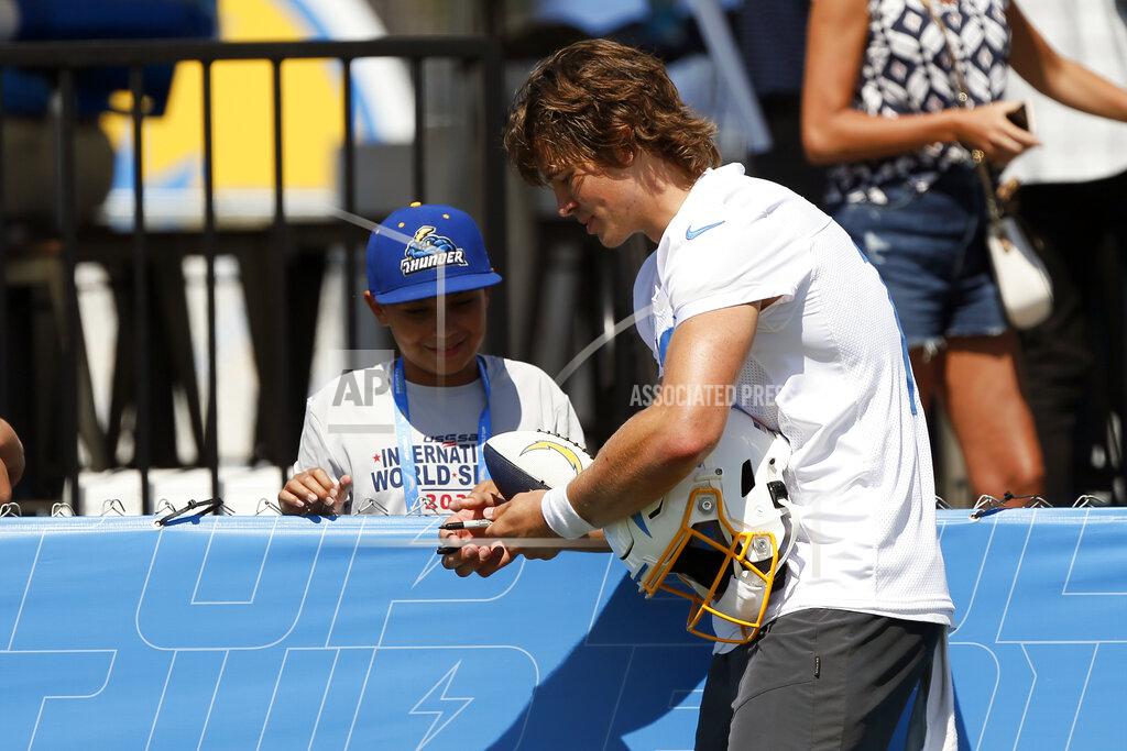 Alex Gallardo Los Angeles Chargers quarterback Justin Herbert, right, signs an autograph for a fan after practice at the NFL football team's training camp in Costa Mesa, Calif., Wednesday, July 28, 2021. (AP Photo/Alex Gallardo)