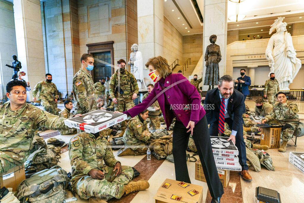 Manuel Balce Ceneta Rep. Vicky Hartzler, R-Mo., and Rep. Michael Waltz, R-Fla., hand pizzas to members of the National Guard gathered at the Capitol Visitor Center, Wednesday, Jan. 13, 2021, in Washington. as the House of Representatives continues with its fast-moving House vote to impeach President Donald Trump, a week after a mob of Trump supporters stormed the U.S. Capitol. (AP Photo/Manuel Balce Ceneta)