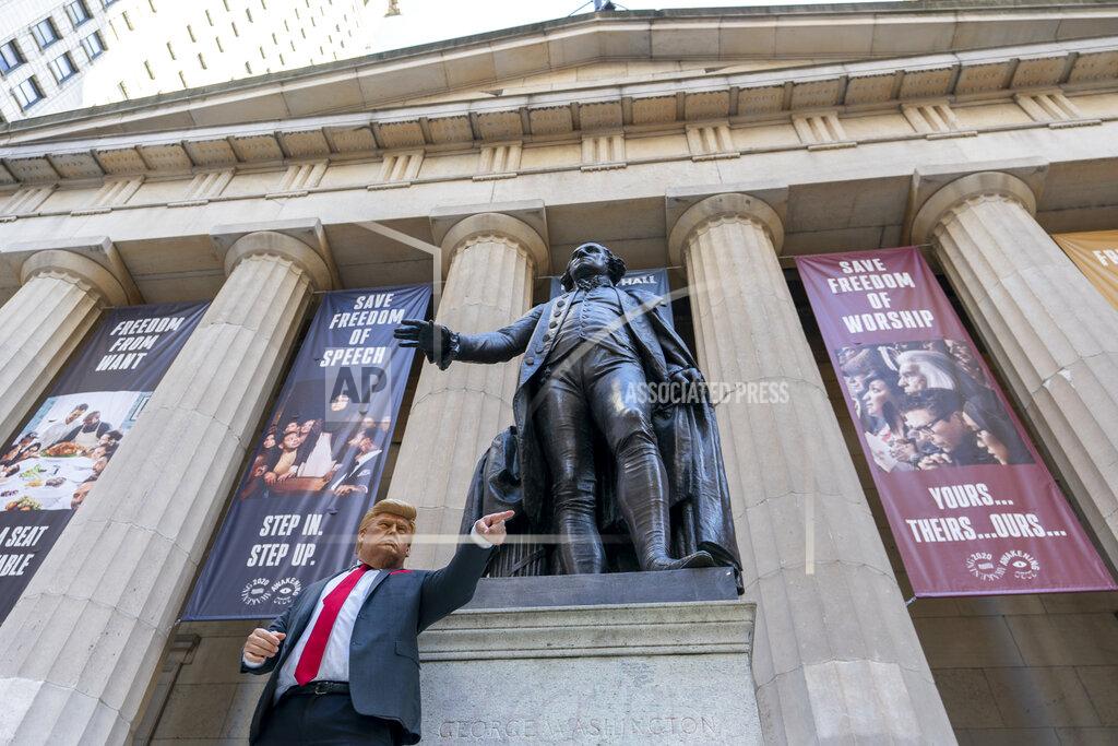 Mary Altaffer A demonstrator wearing a Donald Trump mask stands next to a statue of George Washington at Federal Hall during the Women's March outside the New York Stock Exchange, Saturday, Oct. 17, 2020, in New York. Dozens of Women's March rallies were planned from New York to San Francisco to signal opposition to President Donald Trump and his policies, including the push to fill the seat of late Supreme Court Justice Ruth Bader Ginsburg before Election Day. (AP Photo/Mary Altaffer)
