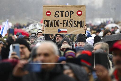 A man holds up a sign reading Stop Covid Fascism, during a protest against measures to tackle surge of COVID-19 infections, in Prague, Sunday, Nov. 28, 2021. Thousands have rallied in the Czech capital to protest the government’s restrictive measures to tackle a record surge of coronavirus infections. The protesters included supporters of a number of fringe political parties and groups that failed to win any parliamentary seats in October’s election. (Ondrej Deml/CTK via AP)