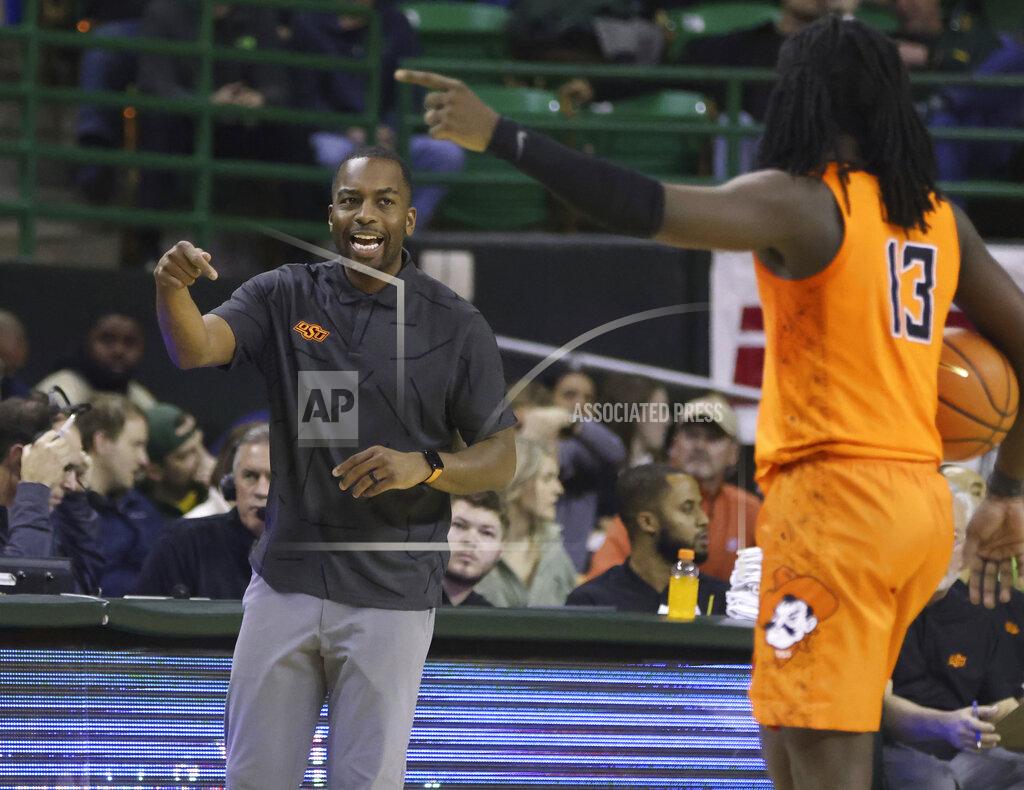Rod Aydelotte Oklahoma State head coach Mike Boynton sends an offensive play to guard Isaac Likekele, right, in the first half of an NCAA college basketball game against Baylor, Saturday, Jan. 15, 2022, in Waco, Texas. (Rod Aydelotte/Waco Tribune-Herald via AP)