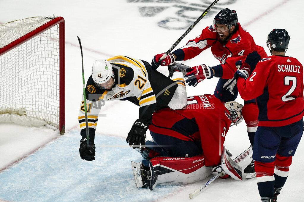 Alex Brandon Boston Bruins left wing Nick Ritchie (21) falls over Washington Capitals goaltender Craig Anderson (31) with Capitals defenseman Brenden Dillon (4) nearby, during the second period of Game 1 of an NHL hockey Stanley Cup first-round playoff series Saturday, May 15, 2021, in Washington. (AP Photo/Alex Brandon)