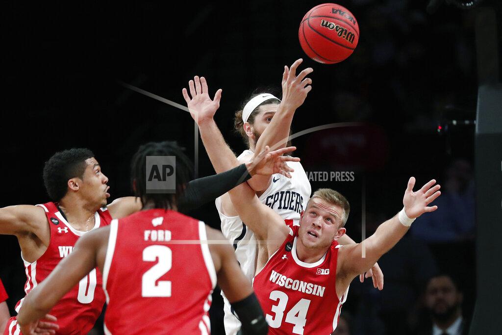Kathy Willens Richmond forward Grant Golden (33) passes as Wisconsin guard Brad Davison (34) tries to block the pass during the first half of an NCAA college basketball game in the Legends Classic, Monday, Nov. 25, 2019, in New York. (AP Photo/Kathy Willens)