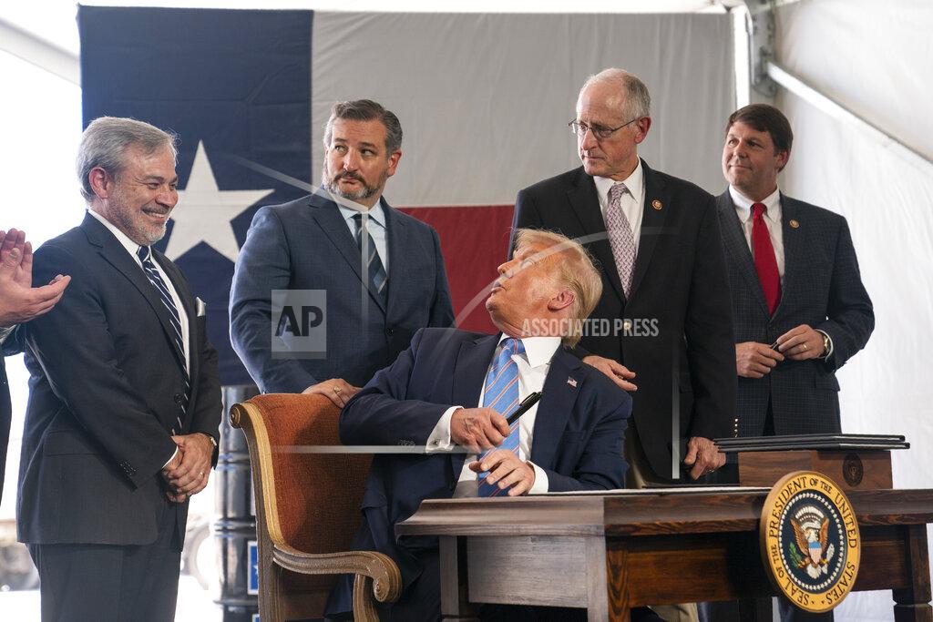 Evan Vucci President Donald Trump talks with Sen. Ted Cruz, R-Texas, as he signs a permit for energy development during a visit to the Double Eagle Energy Oil Rig, Wednesday, July 29, 2020, in Midland, Texas. Sen. Ted Cruz, R-Texas, is second from left. (AP Photo/Evan Vucci)