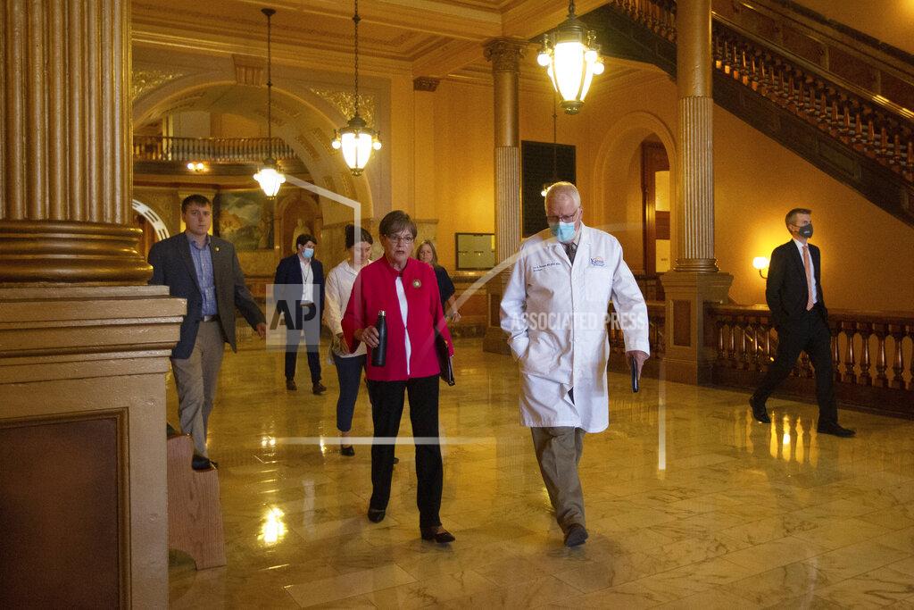 Evert Nelson Kansas Gov. Laura Kelly walks to a news conference with Lee Norman, secretary of Kansas Department of Health and Environment, to give updates regarding the COVID-19 delta variant Wednesday, July 28, 2021 at the Statehouse in Topeka, Kan. Democratic Gov. Laura Kelly on Wednesday issued a new mandate for Kansas residents to wear masks in indoor public spaces even if they've been vaccinated against COVID-19, though there's a good chance she won't be able to make it stick in many places. (Evert Nelson/The Topeka Capital-Journal via AP)