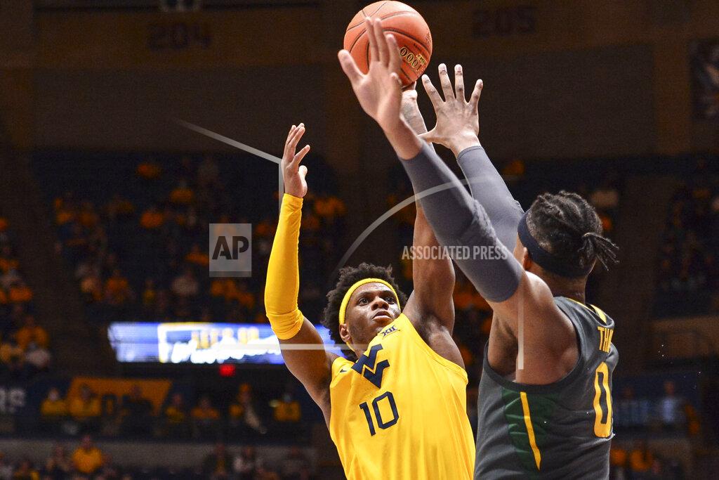William Wotring West Virginia guard Malik Curry (10) shoots while being guarded by Baylor forward Flo Thamba (0) during the first half of an NCAA college basketball game in Morgantown, W.Va., Tuesday, Jan. 18, 2022. (William Wotring)