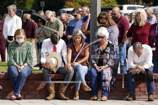 People pray during a vigil at the Collierville Town Hall, Friday, Sept. 24, 2021, in Collierville, Tenn. The vigil is for the person killed and those injured when a gunman attacked people in a Kroger grocery store Thursday before he was found dead of an apparent self-inflicted gunshot wound. (AP Photo/Mark Humphrey)