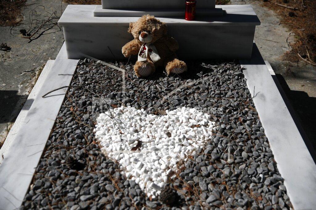 Thanassis Stavrakis A cuddly toy is placed on the grave of a five-year boy from Afghanistan, at Iraion village, on the eastern Aegean island of Samos, Greece, Monday, Feb. 22, 2021.On a hill above a small island village, the sparkling blue of the Aegean just visible through the pine trees, lies a boy’s grave. His first ever boat ride was to be his last - the sea claimed him before his sixth birthday. His 25-year-old father, like so many before him, had hoped for a better life in Europe, far from the violence of his native Afghanistan. But his dreams were dashed on the rocks of Samos, a picturesque Greek island almost touching the Turkish coast. Still devastated from losing his only child, the father has now found himself charged with a felony count of child endangerment. (AP Photo/Thanassis Stavrakis)