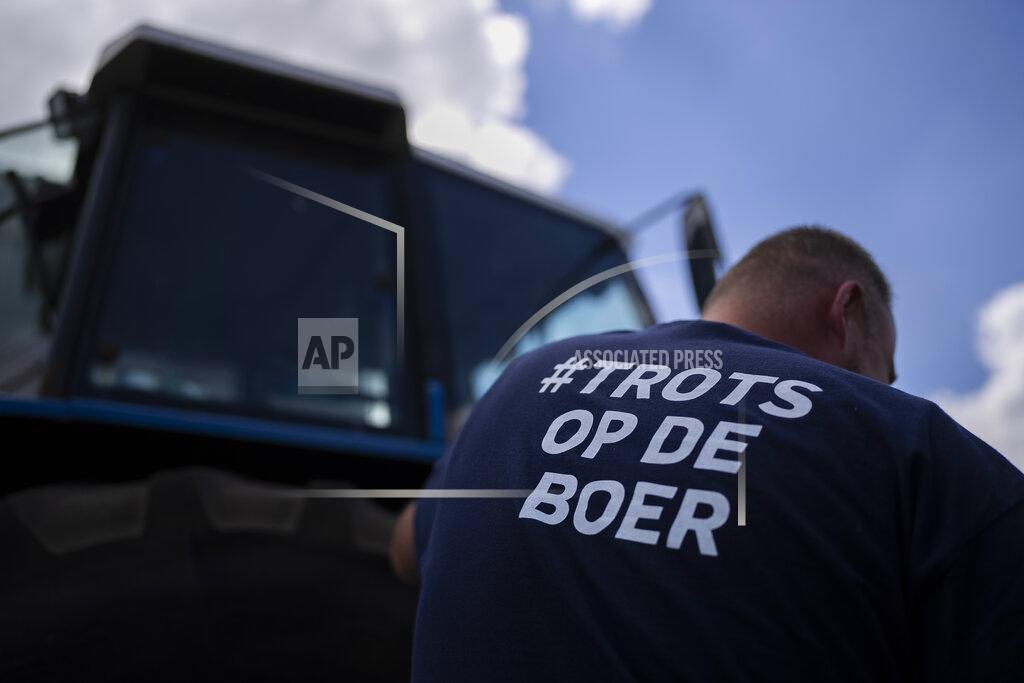 Peter Dejong A protesting farmer wears a t-shirt reading "Proud of the Framer" at a blockade outside a distribution center for supermarket chain Aldi in the town of Drachten, northern Netherlands, Monday, July 4, 2022. Dutch farmers angry at government plans to slash emissions used tractors and trucks Monday to blockade supermarket distribution centers, the latest actions in a summer of discontent in the country's lucrative agricultural sector. (AP Photo/Peter Dejong)