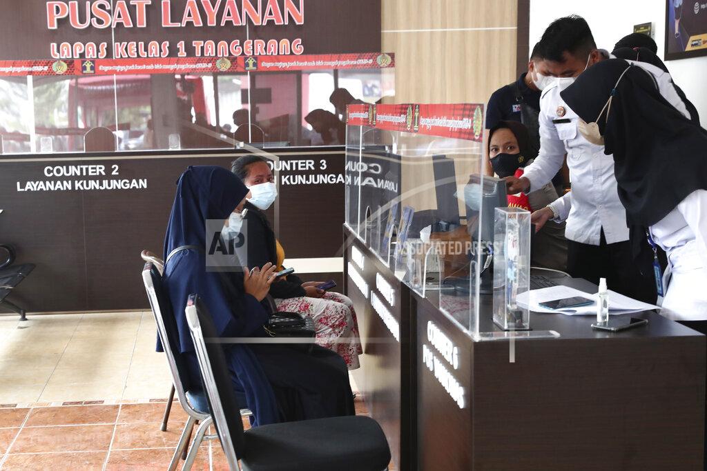 Tatan Syuflana Family members of victims report themselves at the visitors registration desk at Tangerang prison in Tangerang on the outskirts of Jakarta, Indonesia, Wednesday, Sept. 8, 2021. A massive fire raged through the overcrowded prison early Wednesday, killing a number of inmates. (AP Photo/Tatan Syuflana)
