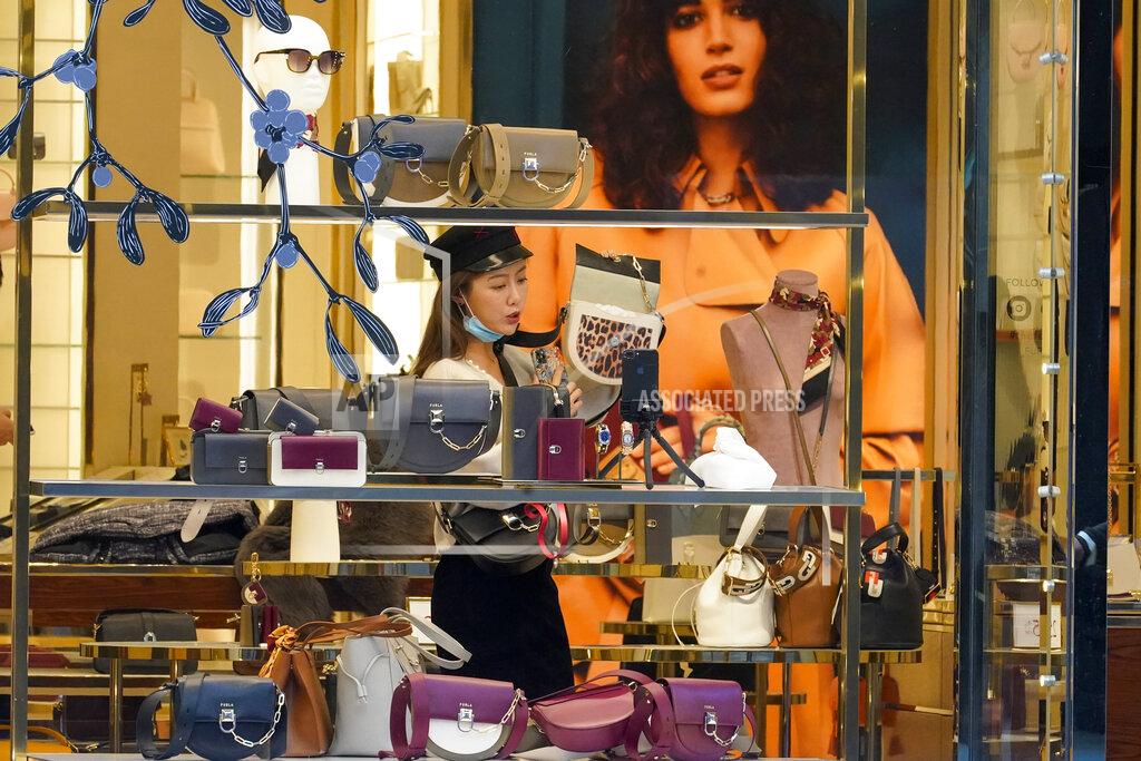 Mary Altaffer A Black Friday shopper uses her smart phone to film herself shopping for handbags at a Furla store along Fifth Avenue, Friday, Nov. 27, 2020, in New York. (AP Photo/Mary Altaffer)