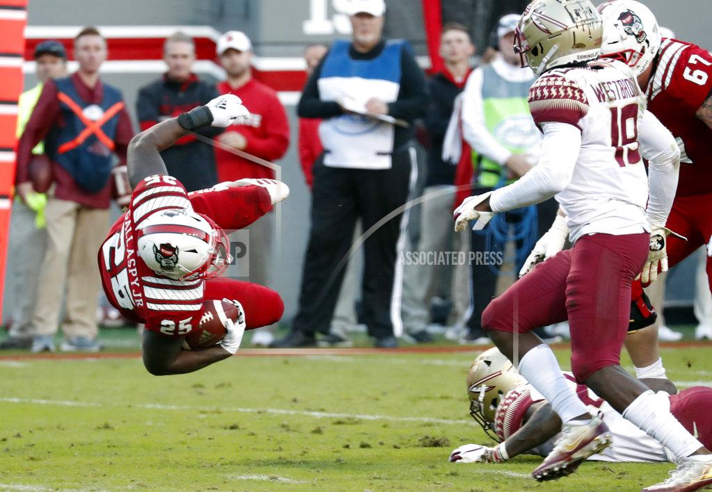 Chris Seward North Carolina State's Reggie Gallaspy II (25) is sent flying after a hit by Florida State's Hamsah Nasirildeen (23) and A.J. Westbrook (19) during the second half of an NCAA college football game in Raleigh, N.C., Saturday, Nov. 3, 2018. (AP Photo/Chris Seward)
