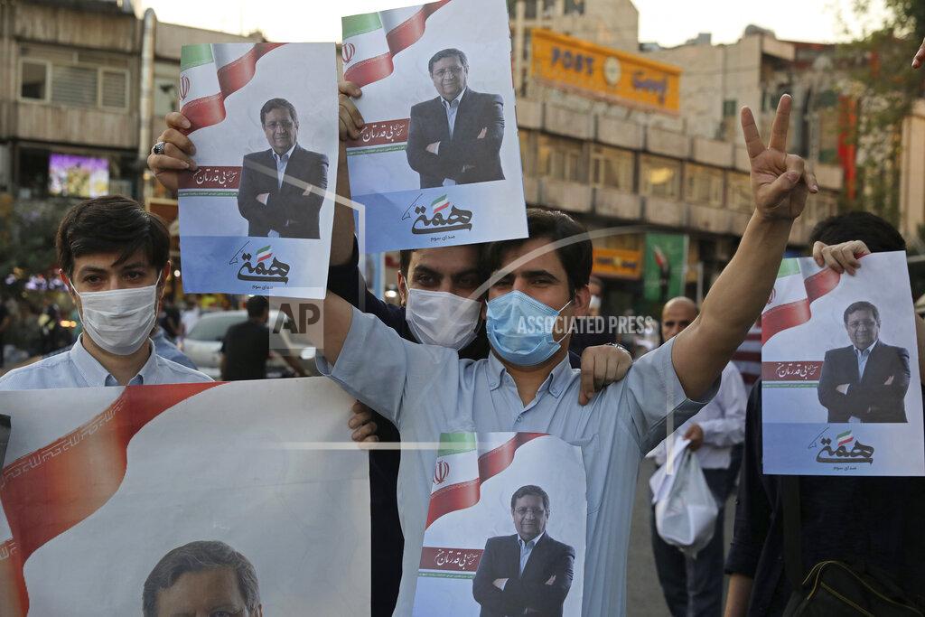 Vahid Salemi Supporters of Abdolnasser Hemmati, a presidential candidate in the June 18, elections, hold signs with his picture, during a street rally in Tehran, Iran, Tuesday, June 15, 2021. Hemmati, a prominent contender in Iran's presidential election appealed Tuesday for better economic and political relations with the West, his most extensive attempt yet to attract reformist voters just days ahead of the poll. (AP Photo/Vahid Salemi)