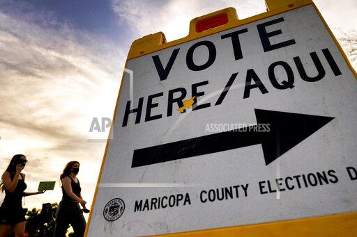 FILE - In this Nov. 3, 2020, file photo, voters deliver their ballot to a polling station in Tempe, Ariz. A review of potential voter fraud cases in the 2020 general election in Arizona's second-largest county ended, Friday, Jan. 14, 2022, with an announcement by prosecutors that none of the 151 cases they reviewed merited criminal charges. The findings in Pima County provide yet another official rebuttal to former President Donald Trump's claims that voter fraud led to his loss in Arizona and other battleground states. (AP Photo/Matt York, File)