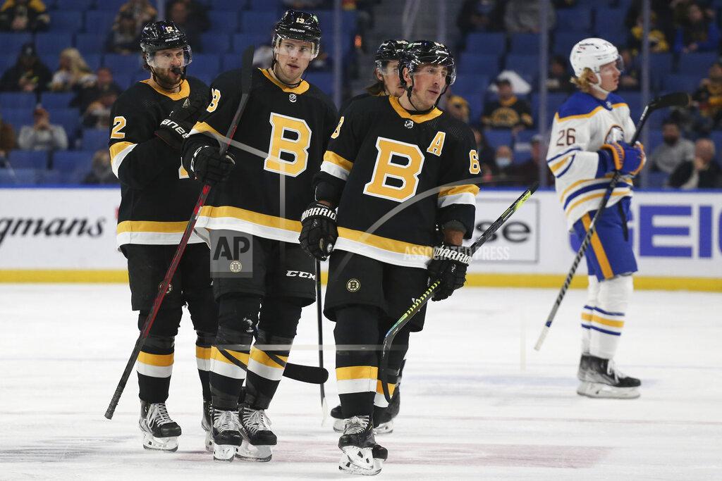Joshua Bessex Boston Bruins center Charlie Coyle, center, skates alongside right wing Craig Smith, left, and center Brad Marchand, right, after scoring during the second period of an NHL hockey game against the Buffalo Sabres, Friday, Oct. 22, 2021, in Buffalo, N.Y. (AP Photo/Joshua Bessex)