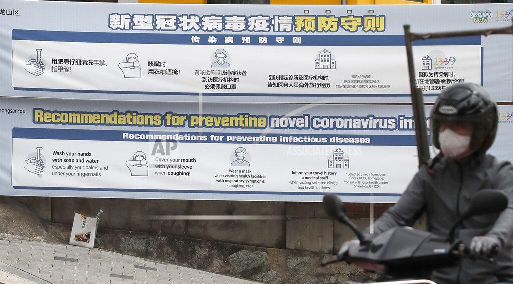 Lee Jin-Man A man wearing a face mask rides a motorcycle past banners showing precautions against the new coronavirus near a temporary closed nightclubs and bars in Seoul, South Korea, Tuesday, May 12, 2020. As South Korea grapples with a new spike in coronavirus infections thought to be linked to nightspots in Seoul, including several popular with gay men, it's also seeing rising homophobia that's making it difficult for sexual minorities to come forward for diagnostic tests. (AP Photo/Lee Jin-man)